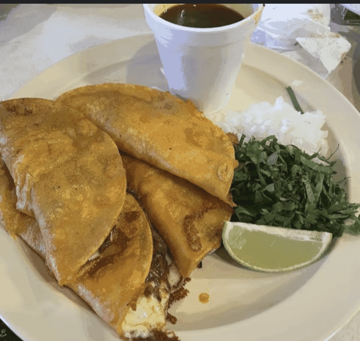 Birria tacos with consomé, rice, cilantro, and lime